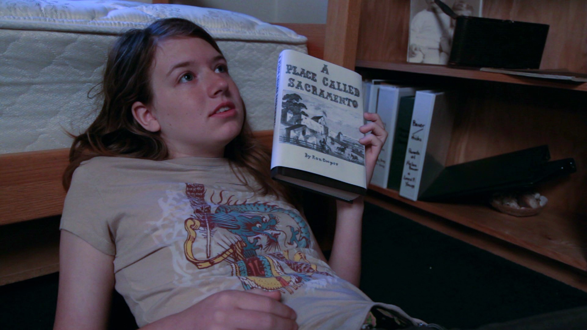 kyriè sierra davenport as sierra reading a place called sacramento book in THE GOLdEN TREE (2010).